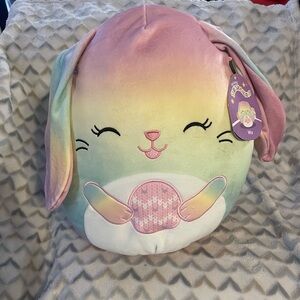 Squishmallows Wu the Rainbow Bunny plush holding an Easter egg stuffed animal to